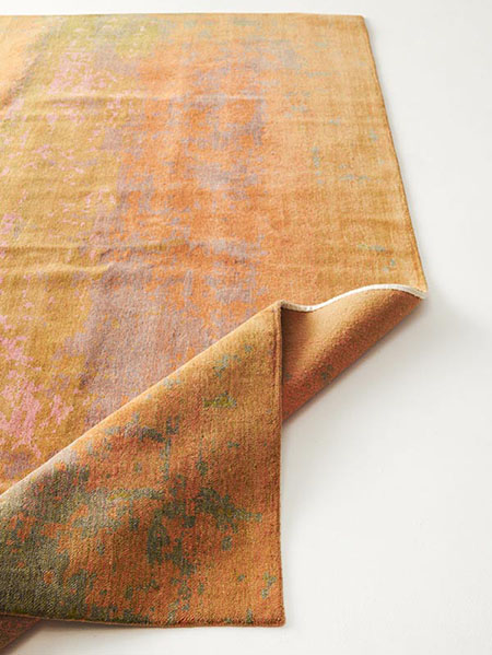 A vibrant rug featuring an intricate design in shades of orange and green